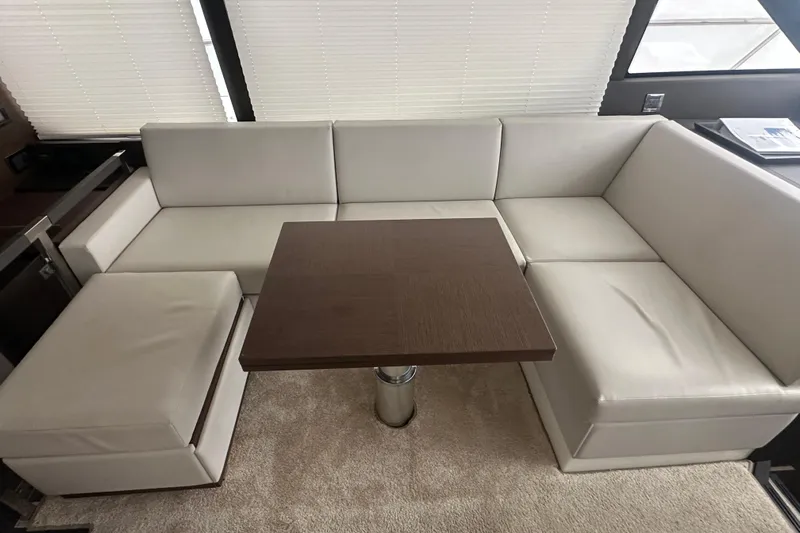 World Wide Yacht Photos Pics Luxurious interior of 2020 Prestige 460 yacht with white leather seating and wooden table.