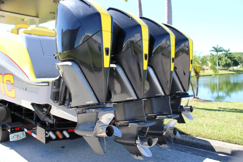  Yacht Photos Pics 2021 Mystic M4200 boat with four powerful outboard engines, parked near a scenic lake.