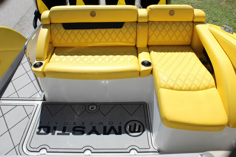  Yacht Photos Pics Yellow quilted seating on 2021 Mystic M4200 boat, featuring cup holders and branded flooring.