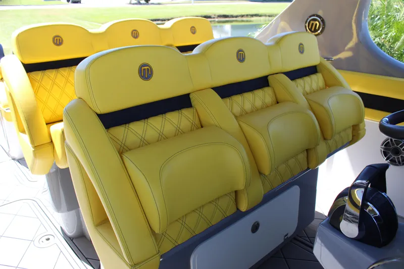  Yacht Photos Pics Yellow leather seats in a 2021 Mystic M4200 boat, featuring diamond stitching and logo detailing.