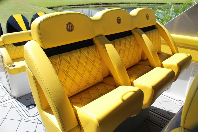  Yacht Photos Pics Yellow leather seats in a 2021 Mystic M4200 boat, featuring diamond stitching and logo detailing.
