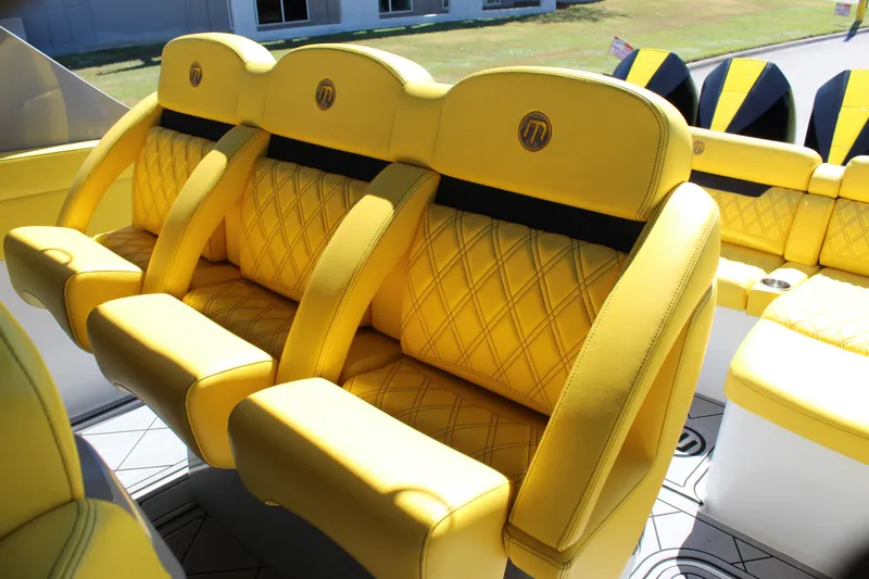  Yacht Photos Pics Yellow leather seats in a 2021 Mystic M4200 boat, featuring diamond stitching and logo.