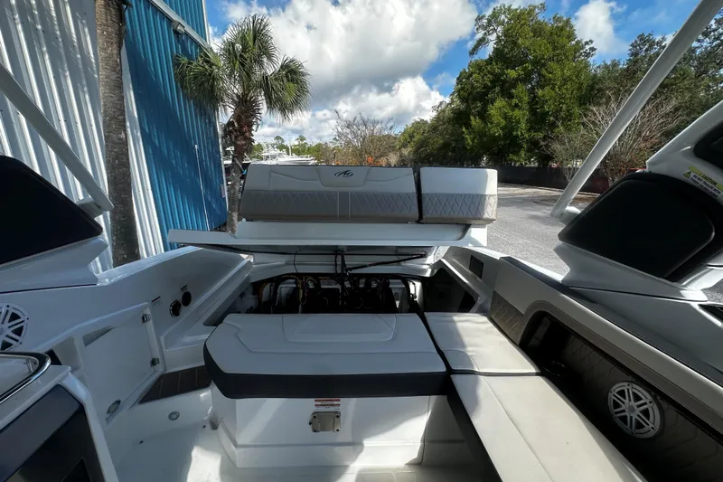  Yacht Photos Pics 2023 Monterey 305SS Super Sport boat interior with open engine compartment, outdoor setting.