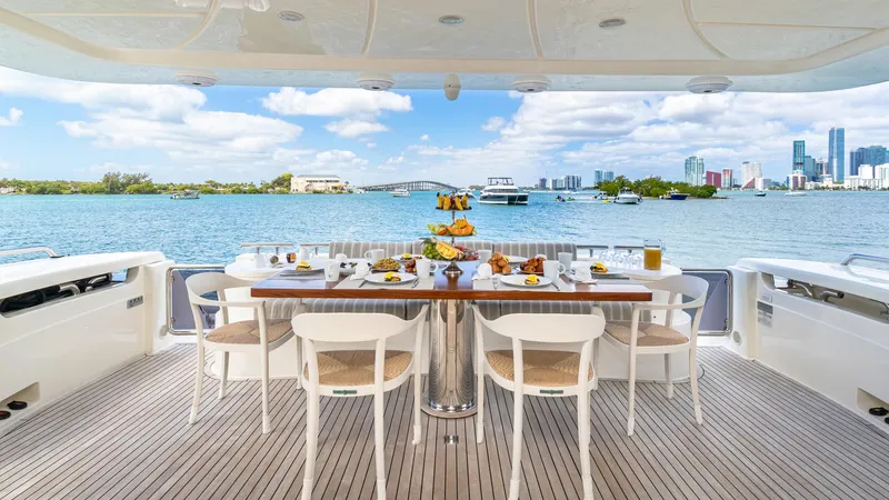 Hoya Saxa Yacht Photos Pics Luxurious dining setup on 2013 Ferretti Yachts 870 FLYBRIDGE with scenic waterfront view.