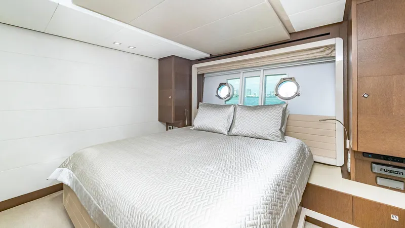 Hoya Saxa Yacht Photos Pics Luxurious bedroom interior on 2013 Ferretti Yachts 870 FLYBRIDGE with elegant bedding and porthole windows.