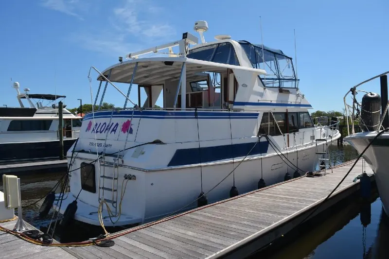 Aloha Yacht Photos Pics 1988 Marine Trader 47 Tradewinds yacht docked at marina under clear blue sky.