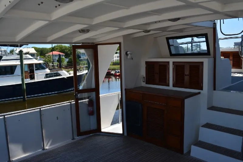 Aloha Yacht Photos Pics 1988 Marine Trader 47 Tradewinds yacht interior with wooden cabinetry and open door to deck.
