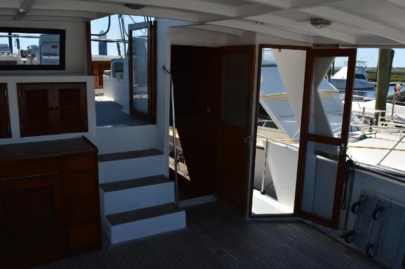 Aloha Yacht Photos Pics 1988 Marine Trader 47 Tradewinds yacht interior with wooden accents and open doors.