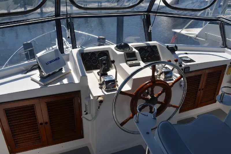 Aloha Yacht Photos Pics 1988 Marine Trader 47 Tradewinds helm with wooden wheel and navigation equipment.
