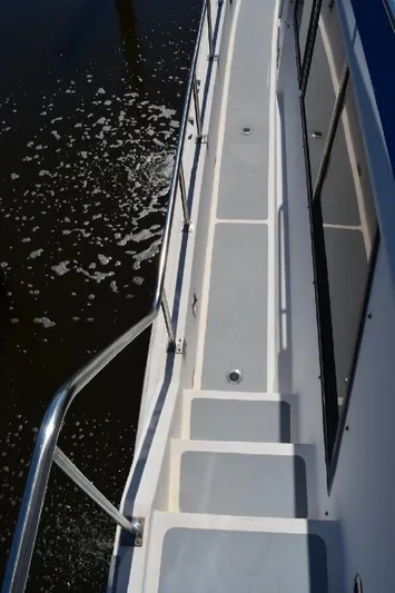 Aloha Yacht Photos Pics 1988 Marine Trader 47 Tradewinds yacht deck with railing, cruising on water.