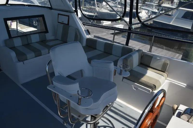 Aloha Yacht Photos Pics 1988 Marine Trader 47 Tradewinds yacht interior with striped seating and captain's chair.