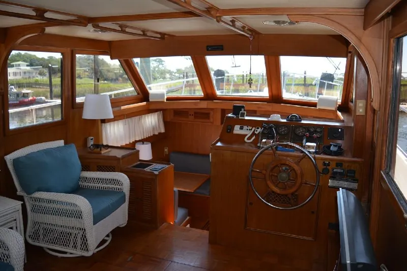 Aloha Yacht Photos Pics Interior of 1988 Marine Trader 47 Tradewinds yacht with wooden helm and seating area.