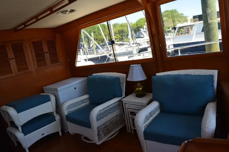 Aloha Yacht Photos Pics Interior of 1988 Marine Trader 47 Tradewinds yacht with wicker chairs and marina view.