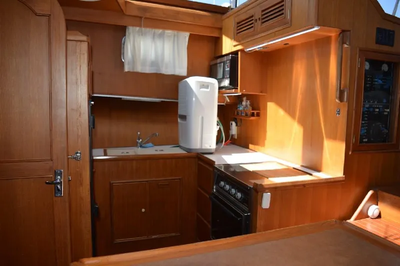 Aloha Yacht Photos Pics 1988 Marine Trader 47 Tradewinds yacht kitchen with wooden cabinetry and modern appliances.