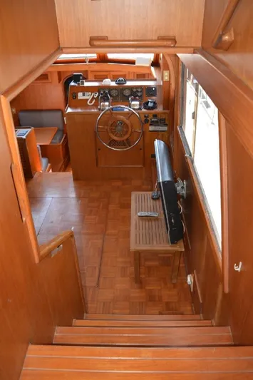 Aloha Yacht Photos Pics Interior view of 1988 Marine Trader 47 Tradewinds yacht with wooden helm and seating area.