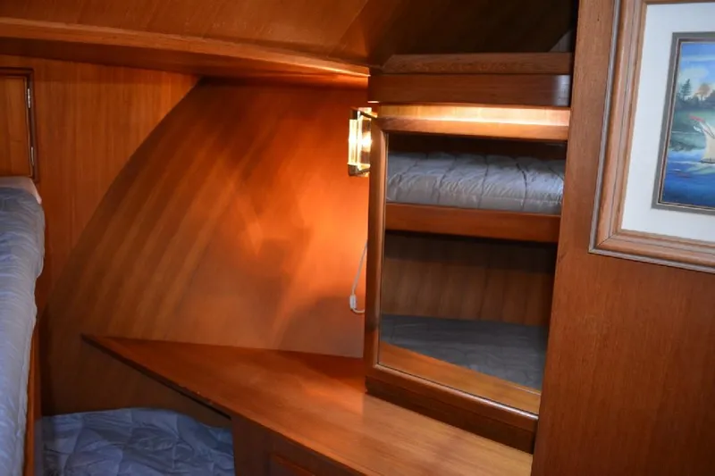 Aloha Yacht Photos Pics 1988 Marine Trader 47 Tradewinds cabin interior with wooden finish and cozy bedding.