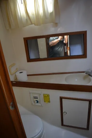 Aloha Yacht Photos Pics 1988 Marine Trader 47 Tradewinds bathroom with sink, mirror, and toilet.
