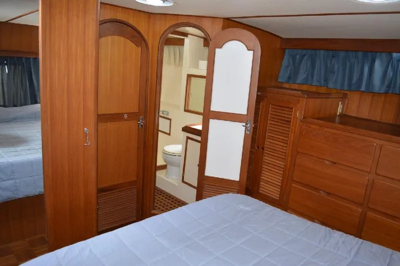 Aloha Yacht Photos Pics 1988 Marine Trader 47 Tradewinds cabin interior with wood paneling and ensuite bathroom.