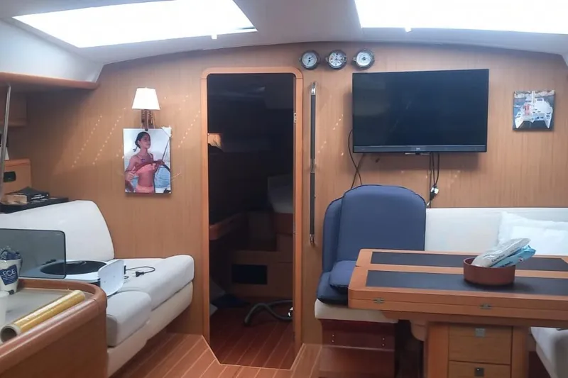  Yacht Photos Pics Interior of 2010 Jeanneau 53 yacht with cozy seating, table, and wall-mounted TV.