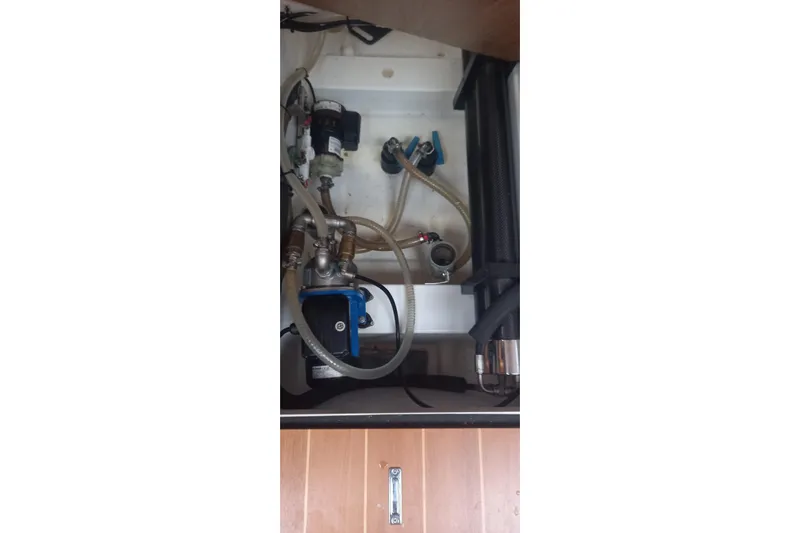  Yacht Photos Pics Engine compartment of a 2010 Jeanneau 53 sailboat, showing hoses and mechanical components.