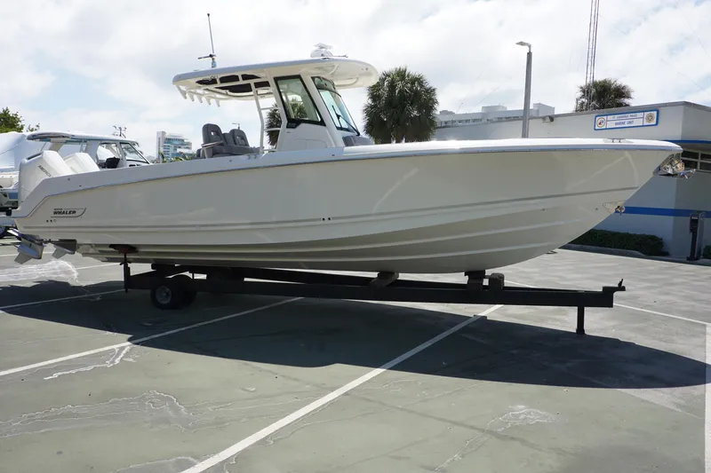 Bwce1064l324 Yacht Photos Pics 2024 Boston Whaler 330 Outrage boat on a trailer in a parking lot.