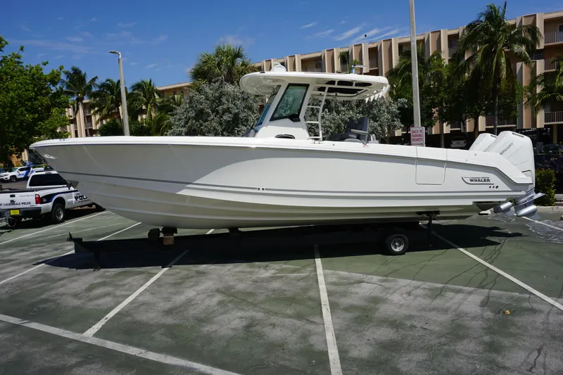 Bwce1064l324 Yacht Photos Pics 2024 Boston Whaler 330 Outrage boat on a trailer in a parking lot.