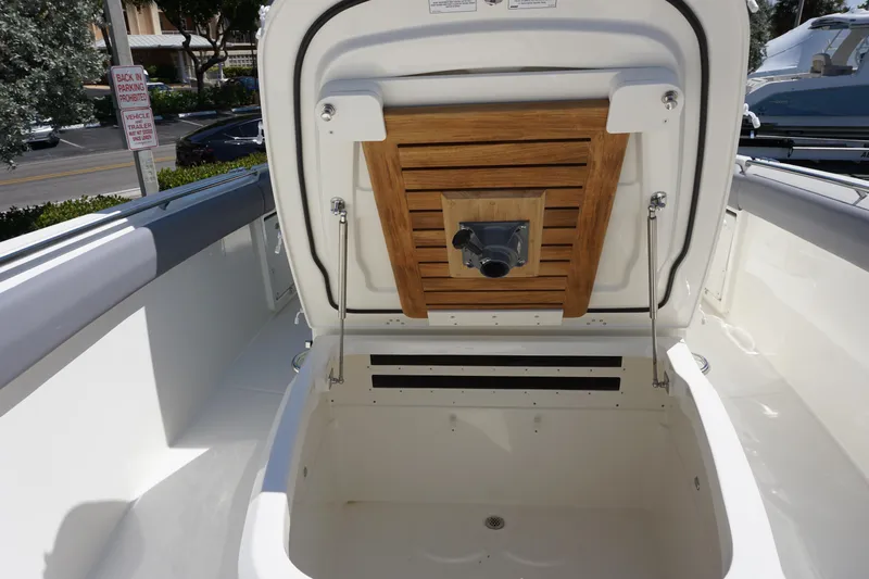 Bwce1064l324 Yacht Photos Pics Boston Whaler 330 Outrage 2024 boat storage compartment with wooden lid open.