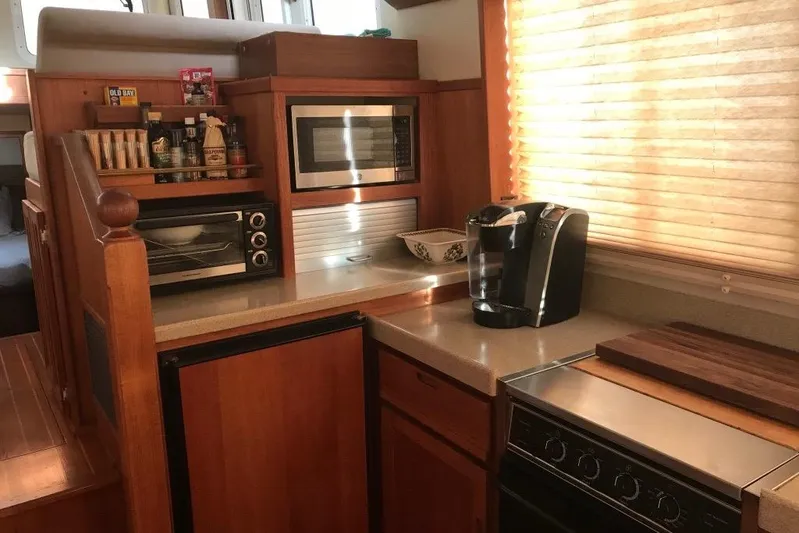 Egret Yacht Photos Pics Cozy kitchen in 2005 Nordic Tug 37 Flybridge with appliances and wooden cabinetry.