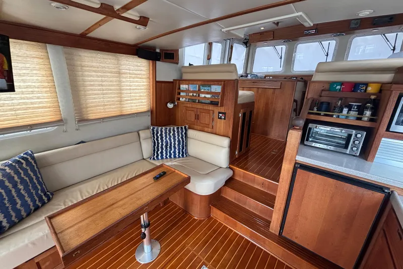 Egret Yacht Photos Pics Interior of 2005 Nordic Tug 37 Flybridge with cozy seating and wooden finishes.