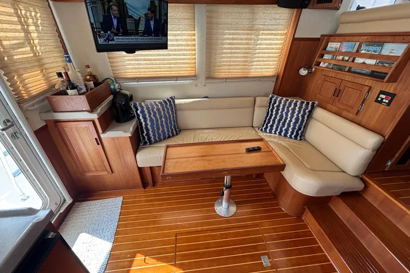 Egret Yacht Photos Pics Interior of 2005 Nordic Tug 37 Flybridge with cozy seating and wooden accents.
