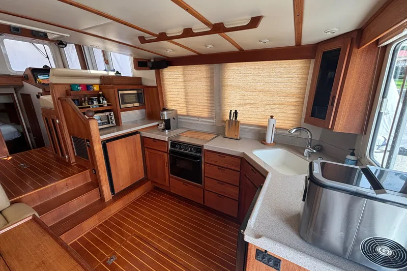 Egret Yacht Photos Pics Interior of 2005 Nordic Tug 37 Flybridge with wooden cabinetry and modern kitchen amenities.