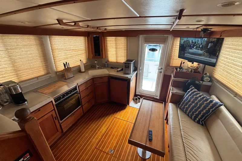 Egret Yacht Photos Pics Interior of 2005 Nordic Tug 37 Flybridge with kitchen, seating, and TV.