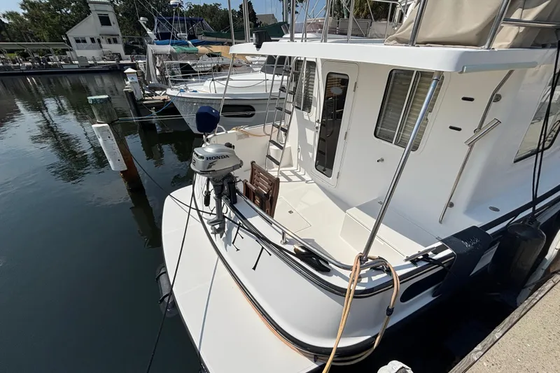 Egret Yacht Photos Pics Aft Shot of 2005 Nordic Tug 37 Flybridge dockside with dingy motor on bracket