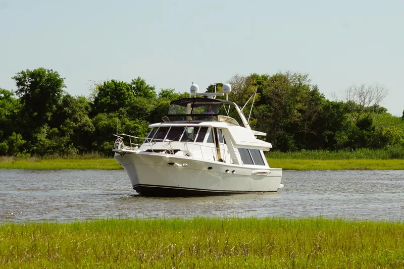  Yacht Photos Pics 2008 Meridian 490 Pilothouse yacht cruising on a serene river with lush greenery.