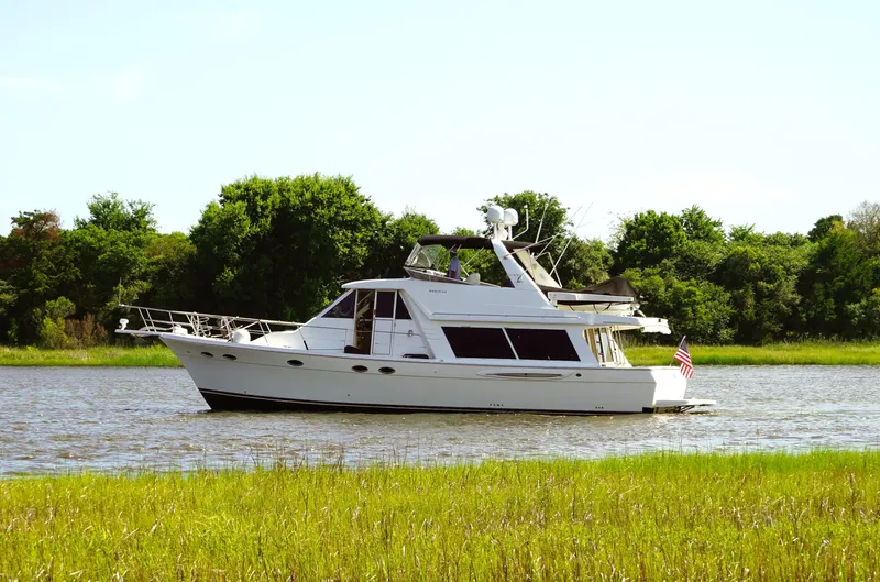  Yacht Photos Pics 2008 Meridian 490 Pilothouse yacht on a serene river with lush green trees.