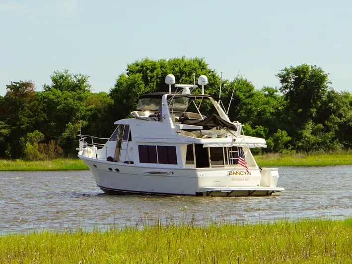  Yacht Photos Pics 2008 Meridian 490 Pilothouse yacht cruising on a serene river with lush greenery.