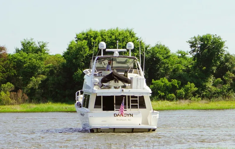  Yacht Photos Pics 2008 Meridian 490 Pilothouse yacht cruising on a river with lush green trees.