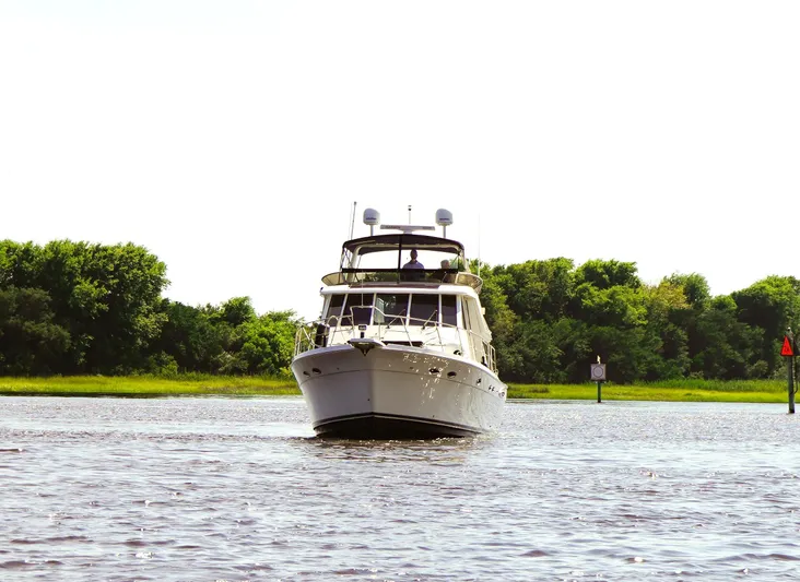  Yacht Photos Pics 2008 Meridian 490 Pilothouse yacht cruising on a calm river with lush green trees.