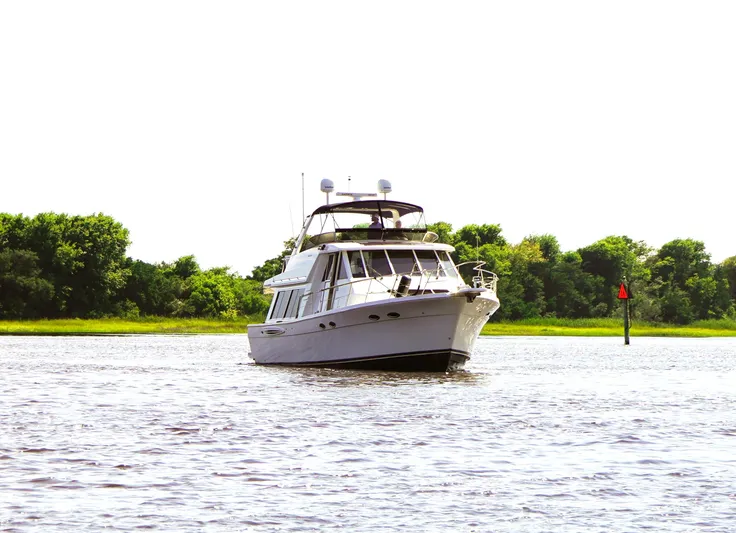  Yacht Photos Pics 2008 Meridian 490 Pilothouse yacht cruising on a serene river with lush green trees.