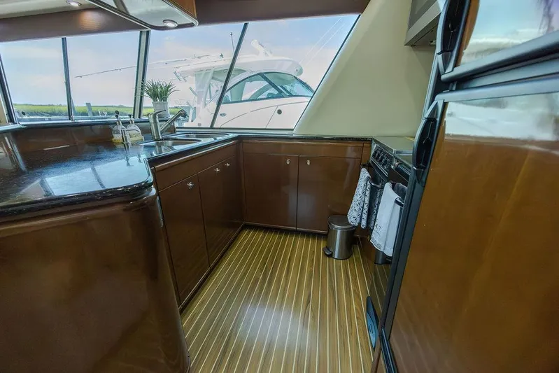  Yacht Photos Pics Luxurious 2008 Meridian 490 Pilothouse yacht kitchen with sleek wood cabinetry and modern appliances.
