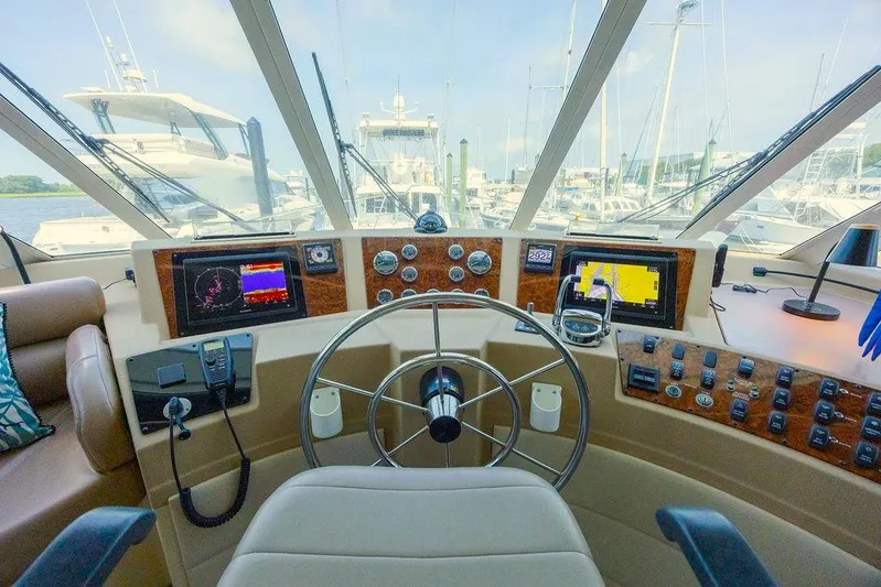  Yacht Photos Pics 2008 Meridian 490 Pilothouse helm with navigation screens and steering wheel in marina setting.