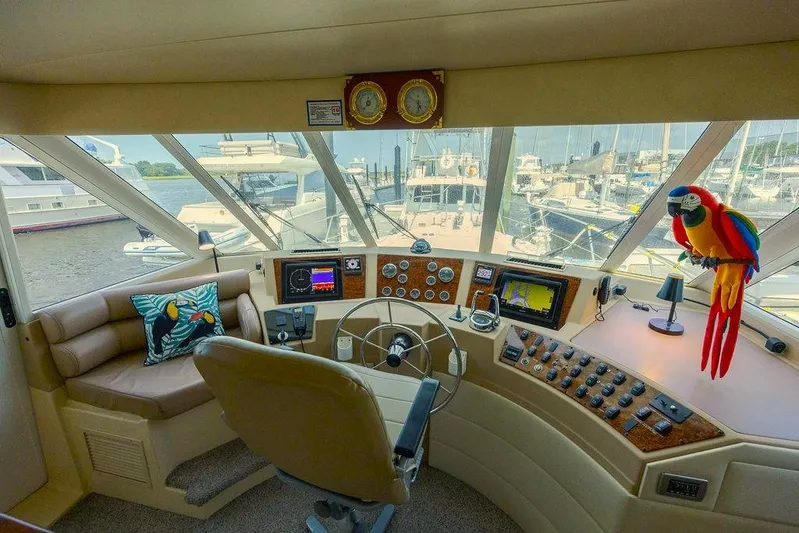  Yacht Photos Pics Pilothouse of 2008 Meridian 490 with navigation controls, plush seating, and a colorful parrot decor.