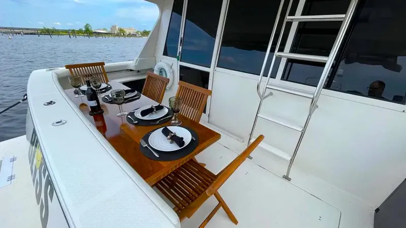 Yacht Photos Pics Outdoor dining setup on 2008 Meridian 490 Pilothouse yacht deck, overlooking water.