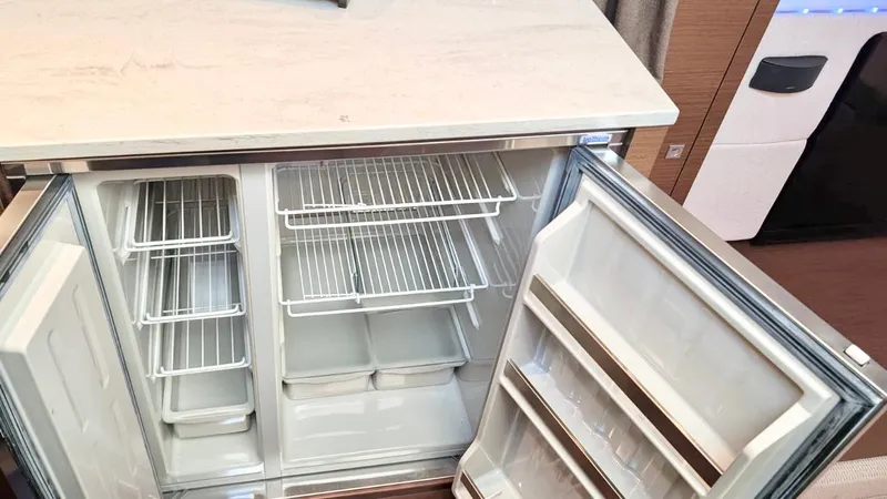  Yacht Photos Pics Open refrigerator inside a 2012 Sea Ray 450 Sundancer yacht, showcasing empty shelves and storage compartments.