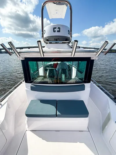  Yacht Photos Pics 2022 Axopar 28 CABIN boat with seating, on calm water under a blue sky.