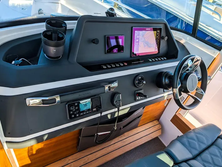  Yacht Photos Pics 2022 Axopar 28 CABIN helm with modern navigation equipment and steering wheel.