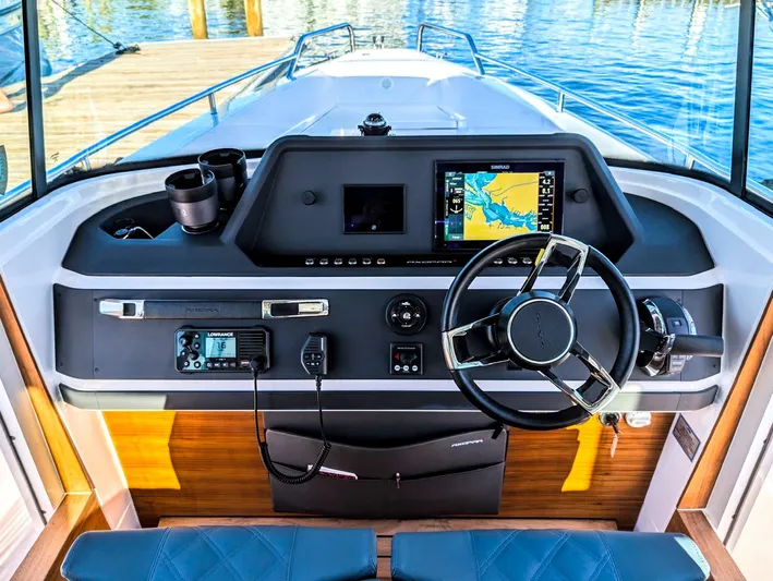  Yacht Photos Pics 2022 Axopar 28 CABIN helm with navigation system and steering wheel, docked by the water.