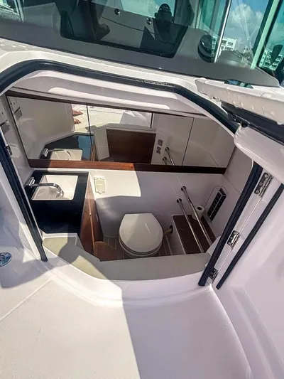  Yacht Photos Pics 2022 Axopar 28 CABIN interior with compact bathroom and modern amenities.