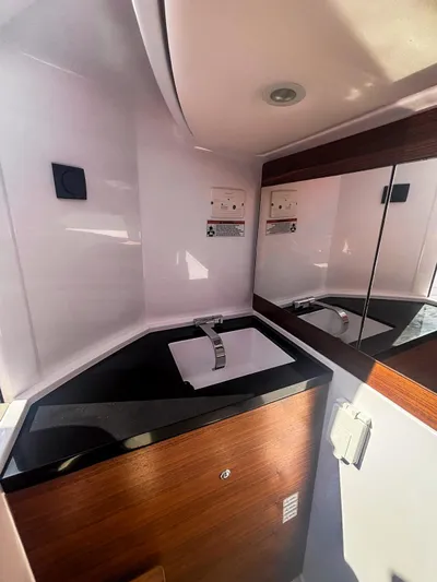  Yacht Photos Pics 2022 Axopar 28 CABIN bathroom with modern sink and mirrored cabinet.