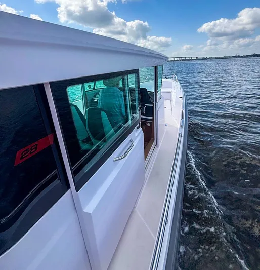  Yacht Photos Pics 2022 Axopar 28 CABIN cruising on a sunny day with clear skies.